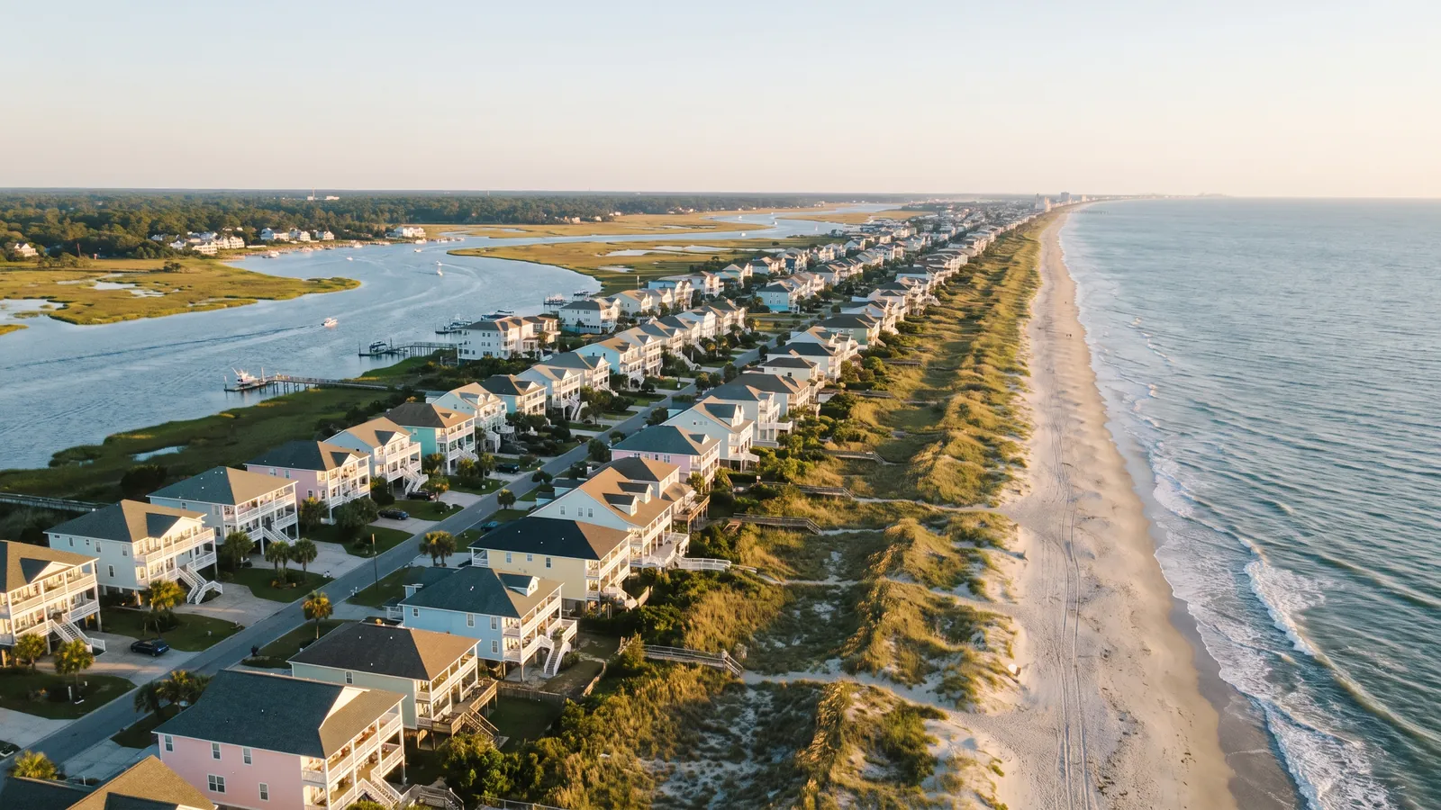 Aerial view of the Grand Strand with rows of beach homes, dunes, the Intracoastal Waterway and the Atlantic Ocean